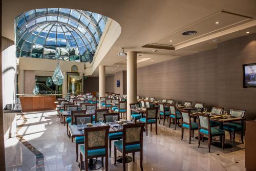 une salle à manger avec des tables et des chaises et un plafond en verre dans l'établissement Howard Johnson Plaza by Wyndham Buenos Aires Florida Street, à Buenos Aires