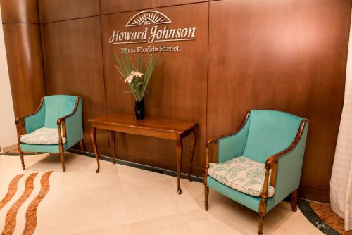 a room with a chair and a clock on the wall at Howard Johnson Plaza Buenos Aires Florida Street by Wyndham in Buenos Aires