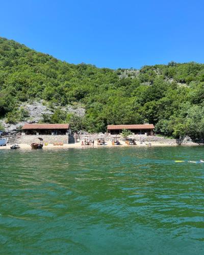 a group of buildings on a beach next to the water at Luxury House Petrovic - Vranjina Skadar Lake in Podgorica