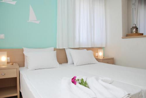 a white bed with a flower on top of it at Thalassenia Studios in Hanioti
