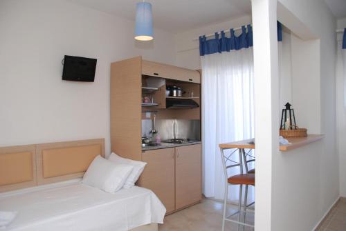 1 dormitorio pequeño con 1 cama y cocina en Thalassenia Studios, en Chaniotis