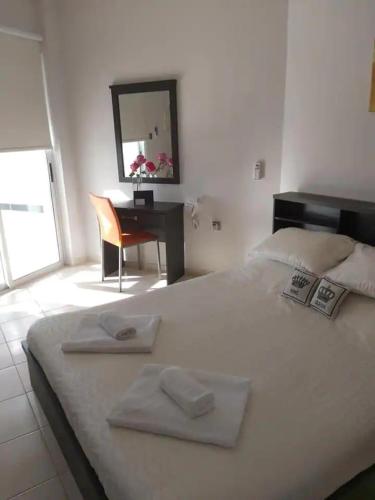 a bedroom with a bed with a desk and a mirror at Panoramic Holidays - Deluxe 1 in Peyia
