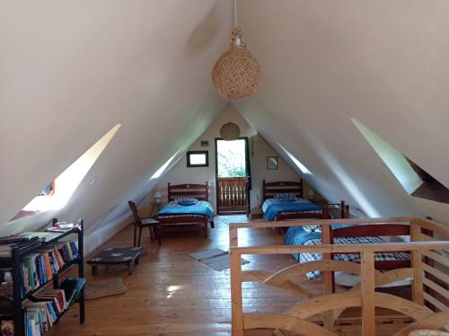 a attic room with two beds and a staircase at Babou Maramures in Breb