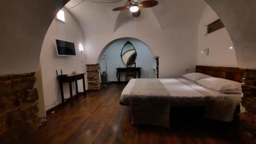 een slaapkamer met een bed en een plafondventilator bij COZYHOME in Catania