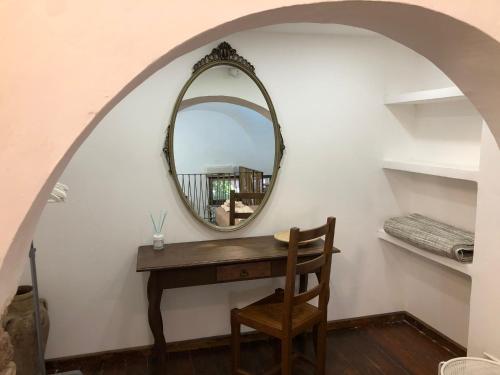 een spiegel aan een muur naast een tafel met een stoel bij COZYHOME in Catania