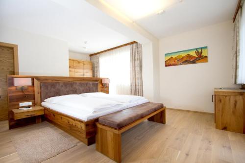 a bedroom with a large bed and a window at Hotel Zirngast in Schladming