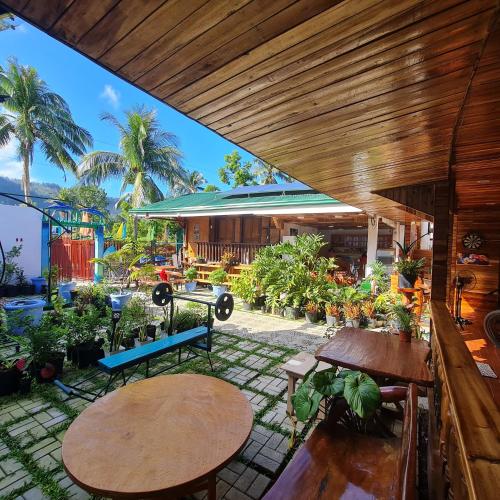 an outdoor patio with tables and potted plants at Aquarius - Port Barton in San Vicente
