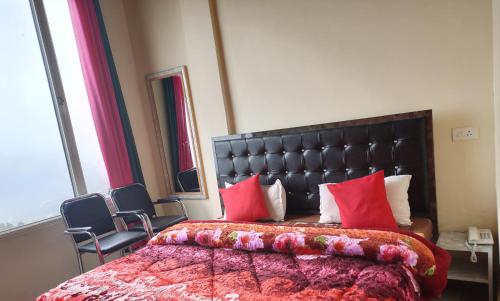a bedroom with a large bed with red pillows at Hotel Sunrise Inn & Restaurant, Kanatal in Chamba