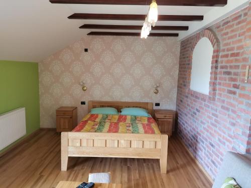 - une chambre avec un lit et un mur en briques dans l'établissement Resort Čokori, à Banja Luka