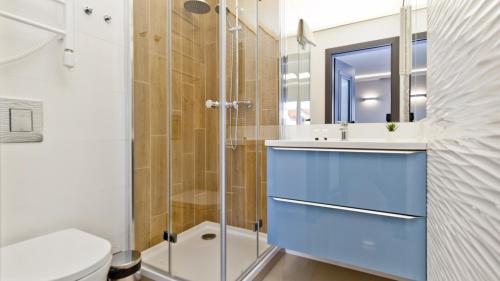 a bathroom with a blue sink and a shower at Apartamenty In Sea Bay Chałupy in Chałupy