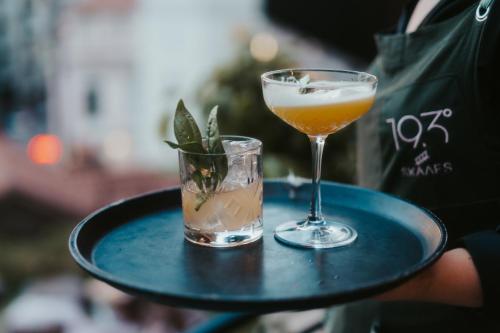 a person holding a tray with a drink on it at 193 Urban Hotel in Patra