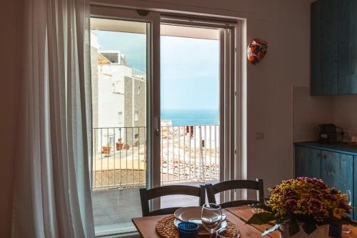 ポリニャーノ・ア・マーレにあるDa Riva Apartment Sea View - Houseaの海の景色を望むキッチン(テーブル付)