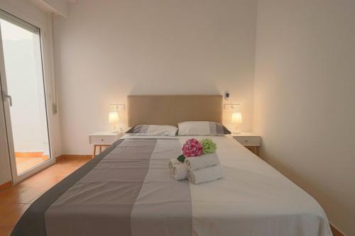 Un dormitorio con una cama grande con una flor rosa. en 062 - Club Náutico 005 - comfortHOLIDAYS, en Santa Pola