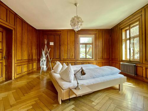 um quarto com uma cama, paredes de madeira e um lustre em Ferienwohnung La Scala em Trin