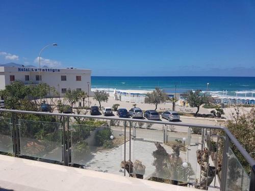 balcón con vistas a la playa y a los coches en Terrazza sul Golfo, en Alcamo