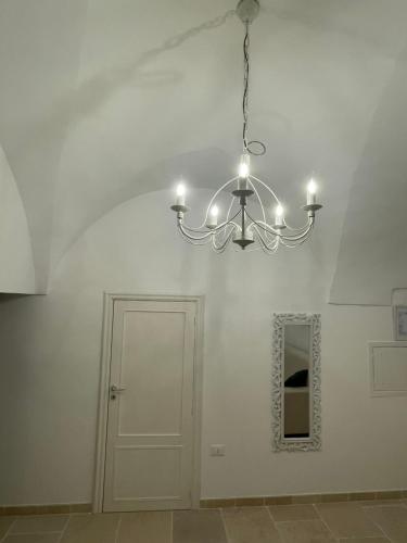 a chandelier hanging in a room with a door at Dimora L’Antico Bijou in Ostuni