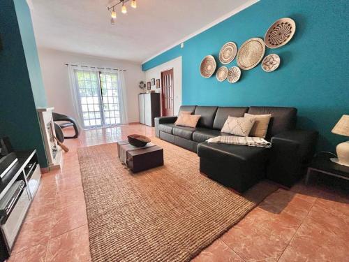 a living room with a couch and plates on the wall at Andorinha Levante in Grândola