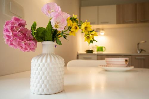 a white vase filled with flowers on a table at Accommodation Baron in Ljubljana
