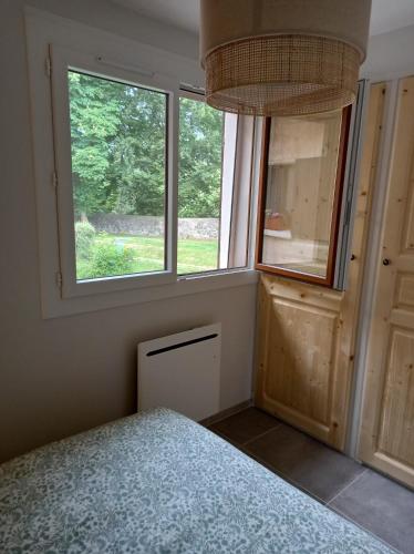 - une chambre avec deux fenêtres et un lit dans l'établissement Le Loutin, à Saint-Bonnet-en-Champsaur