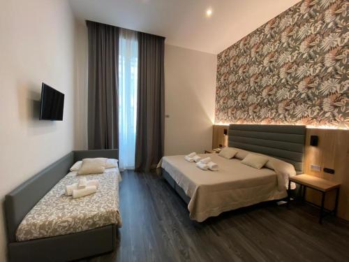 ein Hotelzimmer mit 2 Betten und einem Gemälde an der Wand in der Unterkunft Hotel Delle Camelie in Florenz