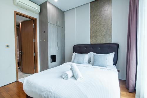 a bedroom with a large white bed with white pillows at Soho Suites @ KLCC in Kuala Lumpur