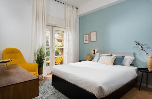 a bedroom with a bed and a desk and a window at Cozy Rehavia for families in Jerusalem