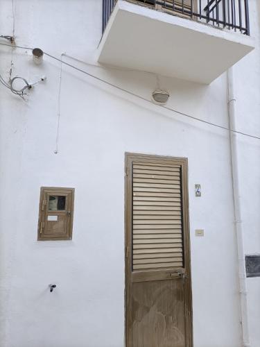 a white building with a door and a window at La casetta a Scopello in Scopello