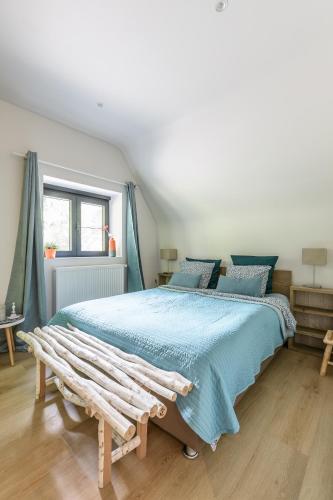 a bedroom with a large bed and a bench at B&B Eat&Sleep in Evergem
