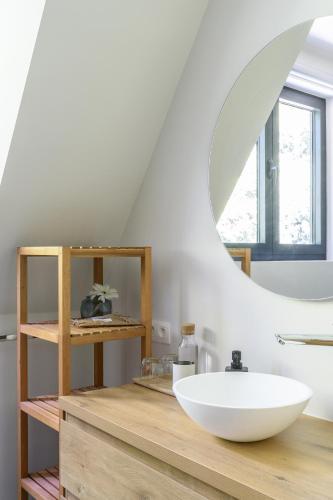a bathroom with a white bowl sink on a wooden counter at B&B Eat&Sleep in Evergem