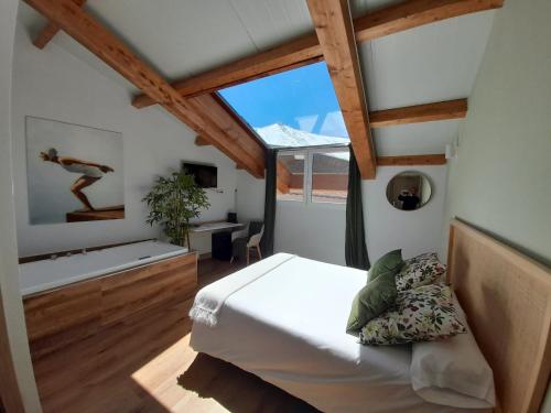 a bedroom with a bed and a large window at Hotel Camino de las Estrellas in Serranillos