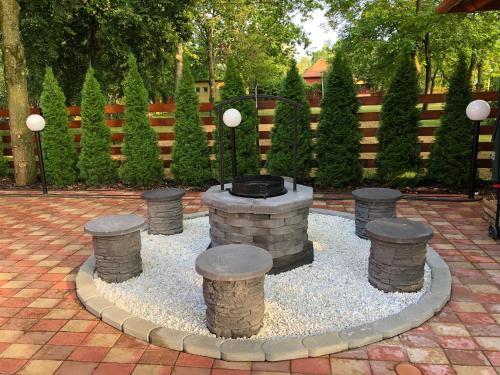 a fountain in a courtyard with pillars and a fence at Boró Apartman in Tiszafüred