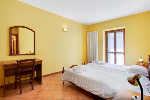 a bedroom with a bed and a desk and a mirror at Residence Appartamento Roma in Civate