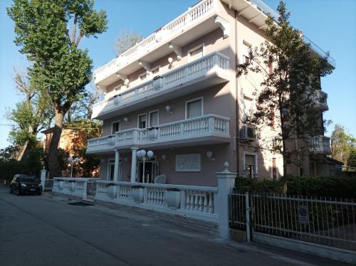 un edificio con balcones al lado de una calle en Hotel Amica en Rímini