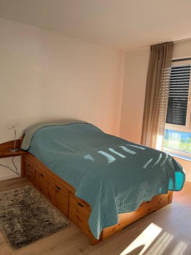 łóżko z zieloną kołdrą w sypialni w obiekcie Ferienwohnung Dariana Schwalbach/Saar w mieście Schwalbach
