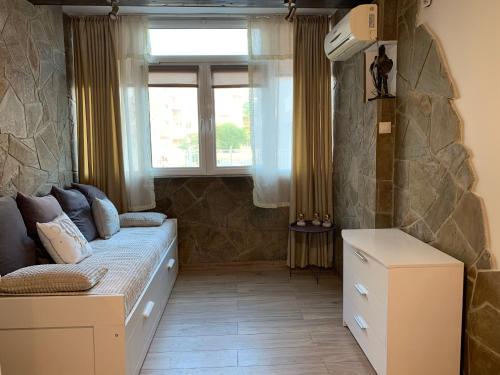 um pequeno quarto com uma cama e uma janela em Анси em Pomorie