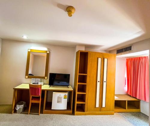 a room with a desk with a computer and a mirror at Sweet Home Hotel Betong in Betong