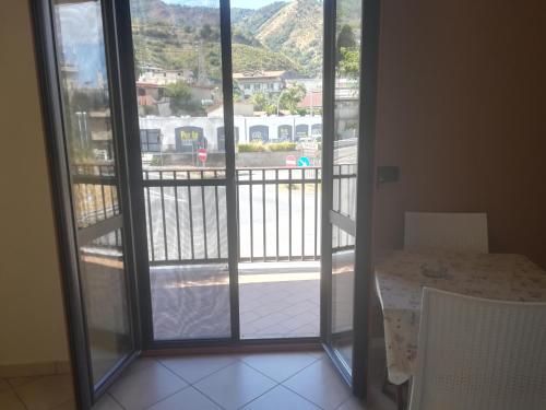 a room with a door open to a balcony with a table at Appartamenti Scilla Paese Albergo in Scilla
