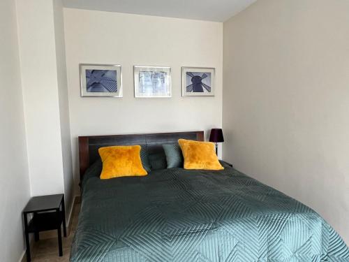 1 dormitorio con 1 cama con 2 almohadas amarillas en Apartament LAPIS Panorama Avangard en Świnoujście