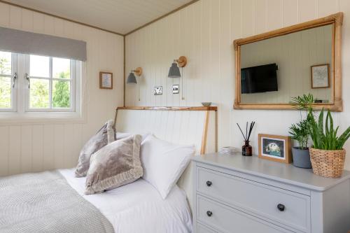 a bedroom with a bed with a dresser and a mirror at Secluded lodge with spectacular views and hot tub! in Bath