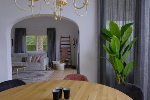 a dining room with a table and a living room at Casa Harmony in Denia