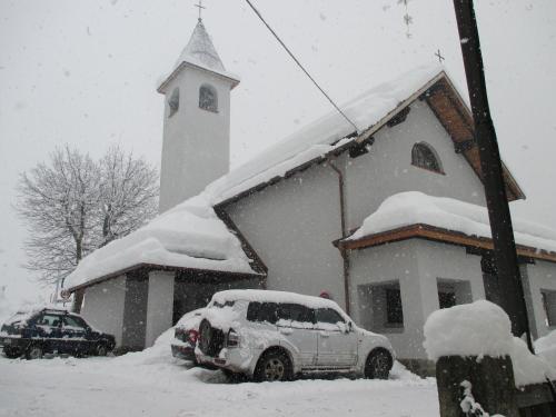 a snow covered church with a car parked in front of it at Maso Pin in Madonna di Campiglio