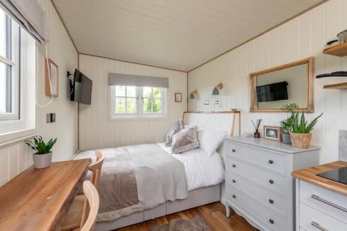 Schlafzimmer mit einem Bett, einem Schreibtisch und einem TV in der Unterkunft Secluded lodge with spectacular views and hot tub! in Bath