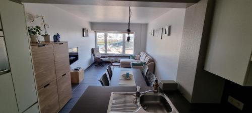 a kitchen with a sink and a living room at Bella Vista Walbo in Blankenberge