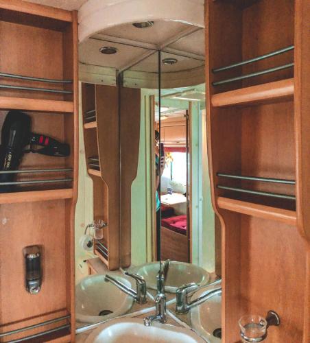a bathroom with a sink and a mirror at Beach House Camp in Na Jomtien