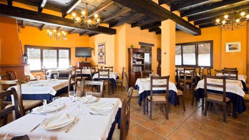 Hotel Maravedí في Pitres: غرفة طعام مع طاولات وكراسي بيضاء