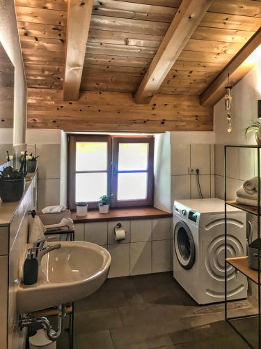 a bathroom with a washing machine and a sink at Ferienwohnung Kaindl in Chieming
