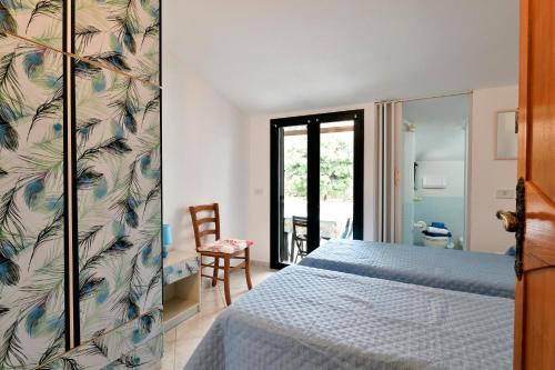 a bedroom with a blue bed and a bathroom at Appartamento Holiday in Cala Gonone