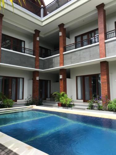 a hotel with a swimming pool in front of a building at 21REDA Cozy Stay in Uluwatu