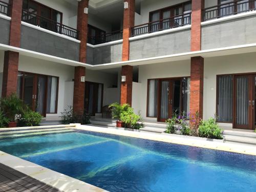 a swimming pool in front of a building at 21REDA Cozy Stay in Uluwatu