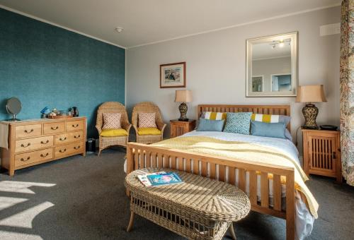 a bedroom with a bed and two chairs and a dresser at Westergate House in York